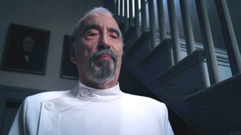 christopher lee in white dentist jacket next to stairs