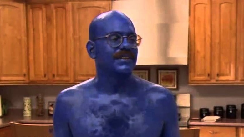 Mężczyzna pomalowany na niebiesko stoi w kuchni
